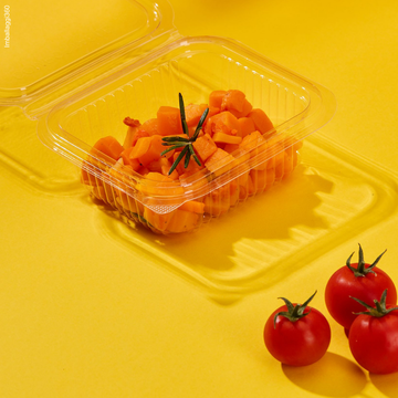 Vaschette trasparenti per gastronomia, mostrate aperta e piene di cib . Pomodorini sparsi tutto su sfondo giallo